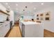 Open-concept kitchen with a large center island, a long countertop, and a dining area in the background at 4234 Gulf Of Mexico Dr # H2, Longboat Key, FL 34228