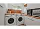 Well-lit laundry room featuring a side-by-side washer and dryer, butcher block countertop, and white cabinets at 4234 Gulf Of Mexico Dr # H2, Longboat Key, FL 34228