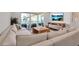 Bright living room featuring a plush sofa, natural wood accents, and sliding glass doors to the balcony at 4234 Gulf Of Mexico Dr # H2, Longboat Key, FL 34228