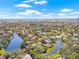 This aerial view showcases a lakeside home surrounded by lush greenery and a serene waterfront setting at 4477 White Cedar Trl, Sarasota, FL 34238