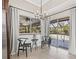 Bright breakfast nook overlooking the pool area, featuring modern light fixtures and elegant drapery at 4477 White Cedar Trl, Sarasota, FL 34238