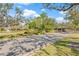 Gated community entrance with lush trees, a water fountain, and a guard house, providing security and curb appeal at 4477 White Cedar Trl, Sarasota, FL 34238