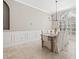 Bright dining room featuring elegant wainscoting, a farmhouse style table, tile flooring, and a modern light fixture at 4477 White Cedar Trl, Sarasota, FL 34238