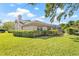 Well-maintained home exterior featuring a green lawn, tidy hedges, and a screened-in patio at 4477 White Cedar Trl, Sarasota, FL 34238