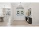 Inviting foyer with double doors, modern light fixture, neutral color palette, and an open view to the formal dining room at 4477 White Cedar Trl, Sarasota, FL 34238