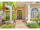 The home features an inviting front entrance with decorative columns, a brick walkway, and lush landscaping at 4477 White Cedar Trl, Sarasota, FL 34238