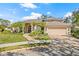 A charming home with manicured landscaping, palm trees, a brick walkway, and a two-car garage at 4477 White Cedar Trl, Sarasota, FL 34238
