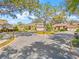 A suburban house with a lush yard and a circular driveway, shaded by mature trees on a sunny day at 4477 White Cedar Trl, Sarasota, FL 34238