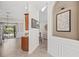 Hallway with neutral walls, art decor, tile flooring, and views into the living spaces at 4477 White Cedar Trl, Sarasota, FL 34238