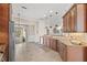 Open kitchen with hardwood cabinets, granite counters, tile flooring, and views to the screened-in outdoor patio at 4477 White Cedar Trl, Sarasota, FL 34238