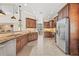 Open kitchen with granite countertops, stainless steel appliances, dark wood cabinets, and a large tile floor at 4477 White Cedar Trl, Sarasota, FL 34238