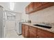 Well-equipped laundry room with washer, dryer, granite countertops, and ample cabinet space, enhancing functionality at 4477 White Cedar Trl, Sarasota, FL 34238