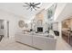 Spacious living room with vaulted ceilings, a fireplace, large windows, a ceiling fan, and a wet bar at 4477 White Cedar Trl, Sarasota, FL 34238