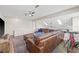 Lofted living room featuring a large sectional, ceiling fans, skylights, and a modern entertainment center at 4477 White Cedar Trl, Sarasota, FL 34238