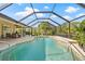 Inviting screened pool area with stone waterfall feature and comfortable outdoor seating at 4477 White Cedar Trl, Sarasota, FL 34238