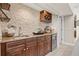 Stylish wet bar area with granite countertops, wooden cabinets, stone accent wall, and a wine rack at 4477 White Cedar Trl, Sarasota, FL 34238