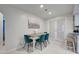 Charming dining area featuring stylish teal chairs and a view to the kitchen through French doors at 470 Leach St, Englewood, FL 34223