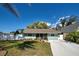 Charming single-story home featuring a well-manicured lawn, light blue exterior, and a long concrete driveway at 470 Leach St, Englewood, FL 34223