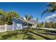 Charming single-story home featuring a well-manicured lawn, white picket fence, and mature trees at 470 Leach St, Englewood, FL 34223