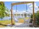 Picturesque lakeside backyard with a hammock swing and lush greenery at 4809 11Th Avenue E Cir, Bradenton, FL 34208