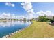 Lakeside backyard with lush green grass, a rock seawall, and neighborhood views at 4809 11Th Avenue E Cir, Bradenton, FL 34208