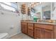 Bathroom features a double sink vanity with granite countertops, wood cabinets, and natural light at 4809 11Th Avenue E Cir, Bradenton, FL 34208