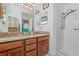 The bathroom has a double sink vanity with granite countertops, wood cabinets, and a tiled shower at 4809 11Th Avenue E Cir, Bradenton, FL 34208