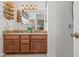 This bathroom features a double sink vanity with granite countertops, wood cabinets, and a shower at 4809 11Th Avenue E Cir, Bradenton, FL 34208