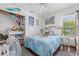 Bright bedroom features coastal décor, wood floors, a ceiling fan and a view of the trees at 4809 11Th Avenue E Cir, Bradenton, FL 34208