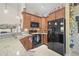 Warm kitchen featuring wooden cabinets, black appliances, and granite countertops at 4809 11Th Avenue E Cir, Bradenton, FL 34208