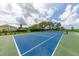Outdoor blue and green tennis court surrounded by lush landscaping, located in a beautiful community at 4809 11Th Avenue E Cir, Bradenton, FL 34208