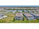 Community aerial view with multiple homes, lush lawns, and screened-in pools, near a large pond at 4968 Seafoam Trl, Bradenton, FL 34211