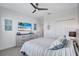 Inviting bedroom with ceiling fan, soft bedding, dresser, coastal art, and ample closet space at 4968 Seafoam Trl, Bradenton, FL 34211