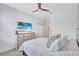 Bright bedroom with ceiling fan, neutral bedding, dresser, coastal art, and ample closet space at 4968 Seafoam Trl, Bradenton, FL 34211