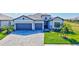 Beautiful home featuring a three-car garage and a well-manicured lawn with lush landscaping at 4968 Seafoam Trl, Bradenton, FL 34211