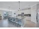 Spacious kitchen featuring a large island with seating, white cabinetry, and stainless steel appliances at 4968 Seafoam Trl, Bradenton, FL 34211