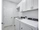 Efficient laundry room featuring modern washer and dryer, ample cabinet space, and a utility sink at 4968 Seafoam Trl, Bradenton, FL 34211