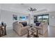 Bright living room with comfortable seating, modern ceiling fan, and large sliding glass doors at 4968 Seafoam Trl, Bradenton, FL 34211
