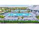 Expansive pool area featuring multiple pools, sun loungers, umbrellas, and palm trees for relaxation at 4968 Seafoam Trl, Bradenton, FL 34211