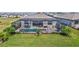 Aerial view of a screened-in pool and patio area, surrounded by well-manicured lawn and landscaping at 4968 Seafoam Trl, Bradenton, FL 34211
