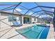 Screened-in pool boasts a hot tub and comfortable lounge furniture on a brick patio, perfect for relaxation at 4968 Seafoam Trl, Bradenton, FL 34211