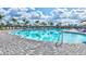 Resort-style community pool with lounge chairs, umbrellas, and palm trees under a sunny sky at 4968 Seafoam Trl, Bradenton, FL 34211
