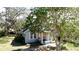 Charming single-story home featuring mature trees and a welcoming front porch with classic column supports at 617 35Th W St, Bradenton, FL 34205