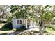 Charming single-story home featuring mature trees and a welcoming front porch with classic column supports at 617 35Th W St, Bradenton, FL 34205