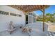 Outdoor seating area under a wooden pergola, complemented by comfortable furniture and access to the home at 619 Buttonwood Dr, Longboat Key, FL 34228