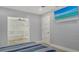 Bedroom with a view into the bathroom with soaking tub, large screen TV, and neutral color palette at 619 Buttonwood Dr, Longboat Key, FL 34228