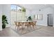 Bright dining room with a large window, a white table, six chairs, and light wood flooring at 619 Buttonwood Dr, Longboat Key, FL 34228
