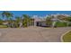 Elegant modern home with large windows, lush landscaping, and a brick-paved driveway at 619 Buttonwood Dr, Longboat Key, FL 34228