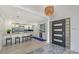 Bright foyer with modern light fixture flowing into the kitchen with new white cabinets and modern appliances at 619 Buttonwood Dr, Longboat Key, FL 34228
