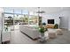 Open living room with floor-to-ceiling windows, a white couch, a ceiling fan, and light wood flooring at 619 Buttonwood Dr, Longboat Key, FL 34228